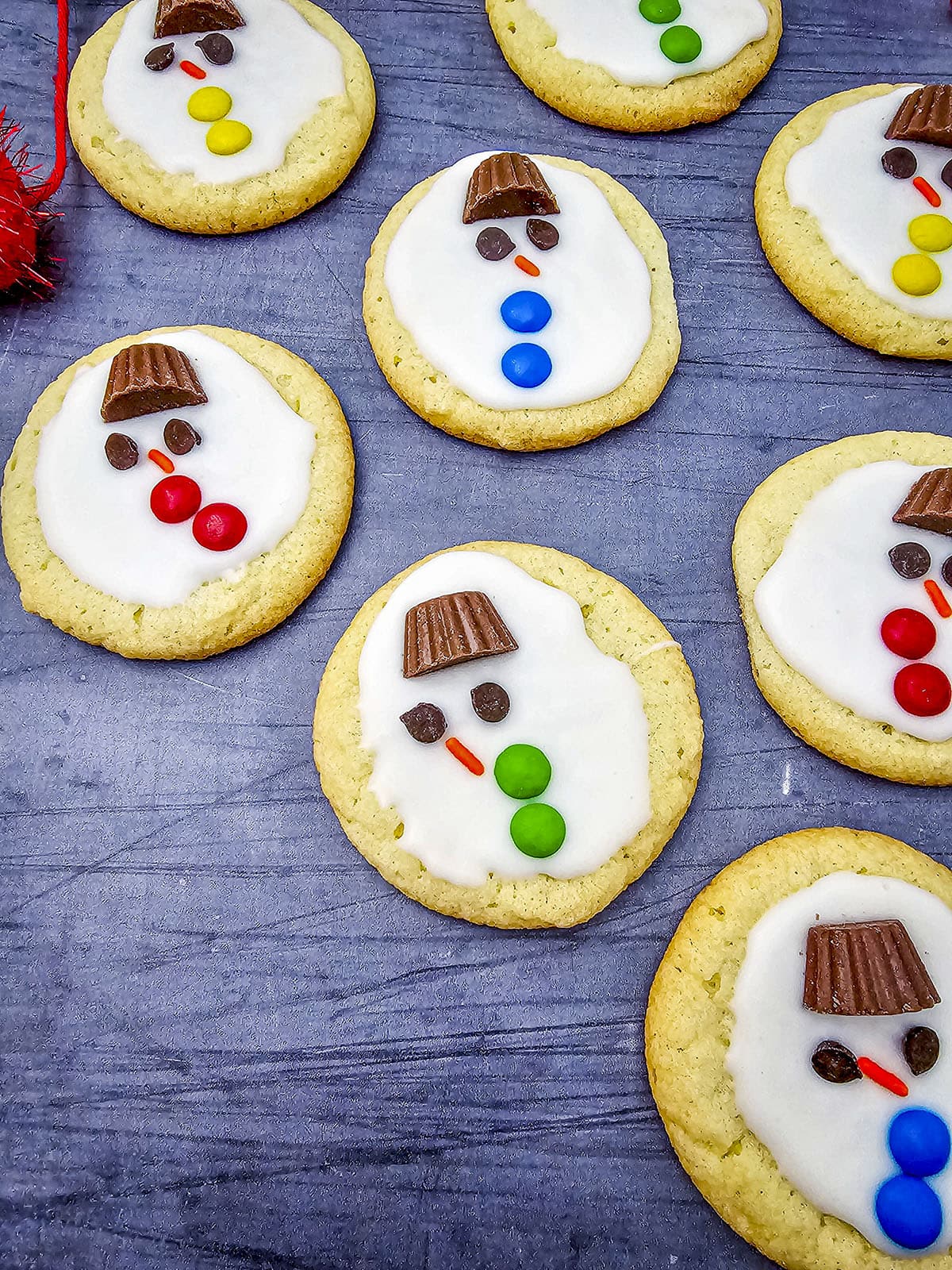 5 sugar cookies with melted snowman candy on top.