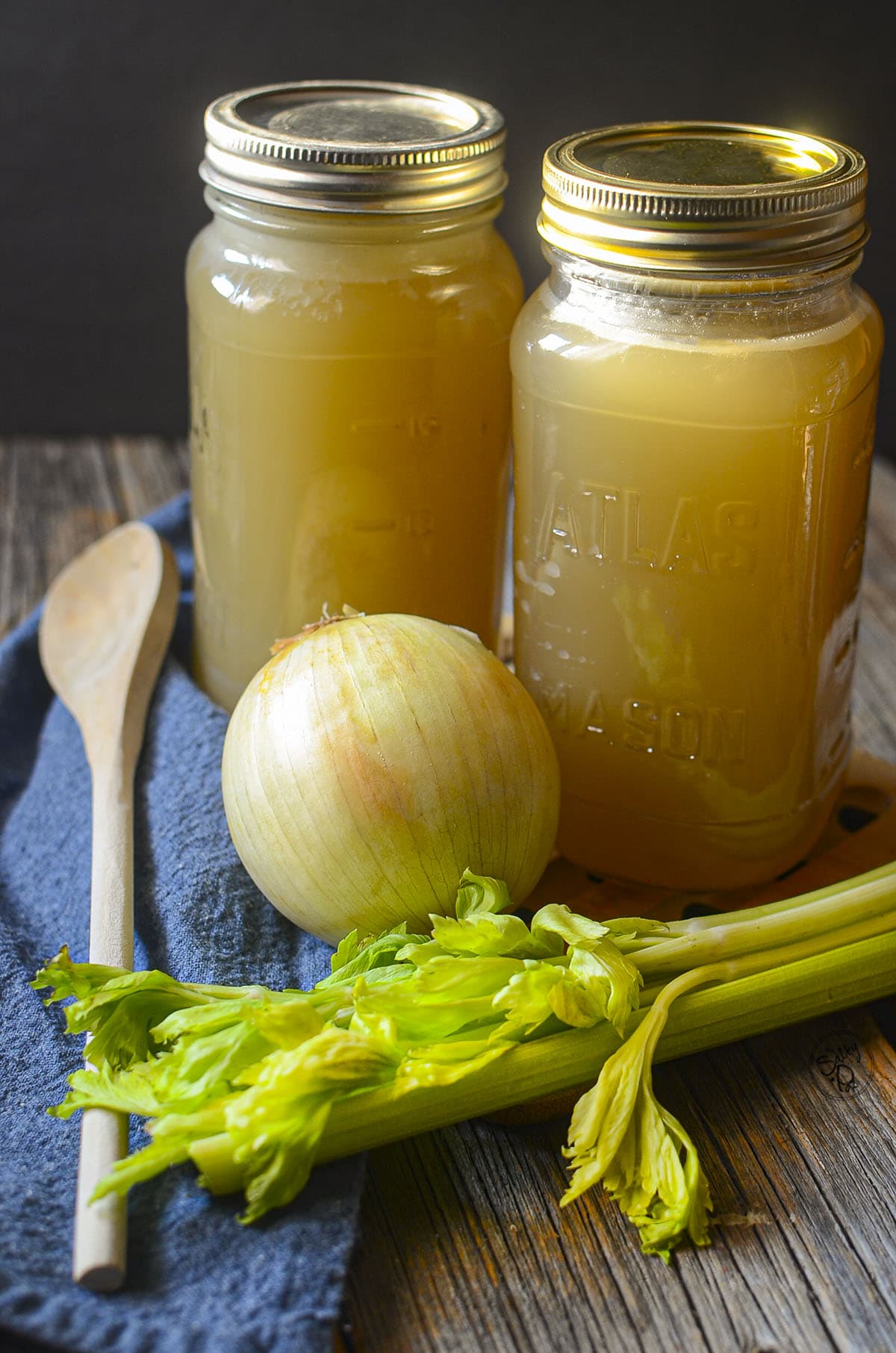 Pork hock stock in jars on a wooden table.
