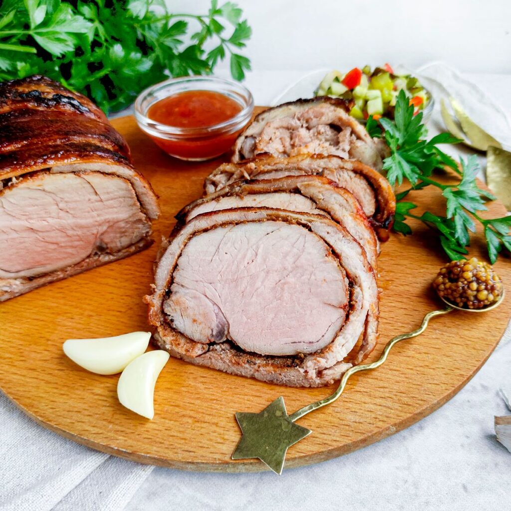 Image of Air Fryer bacon wrapped pork loin on a wooden board