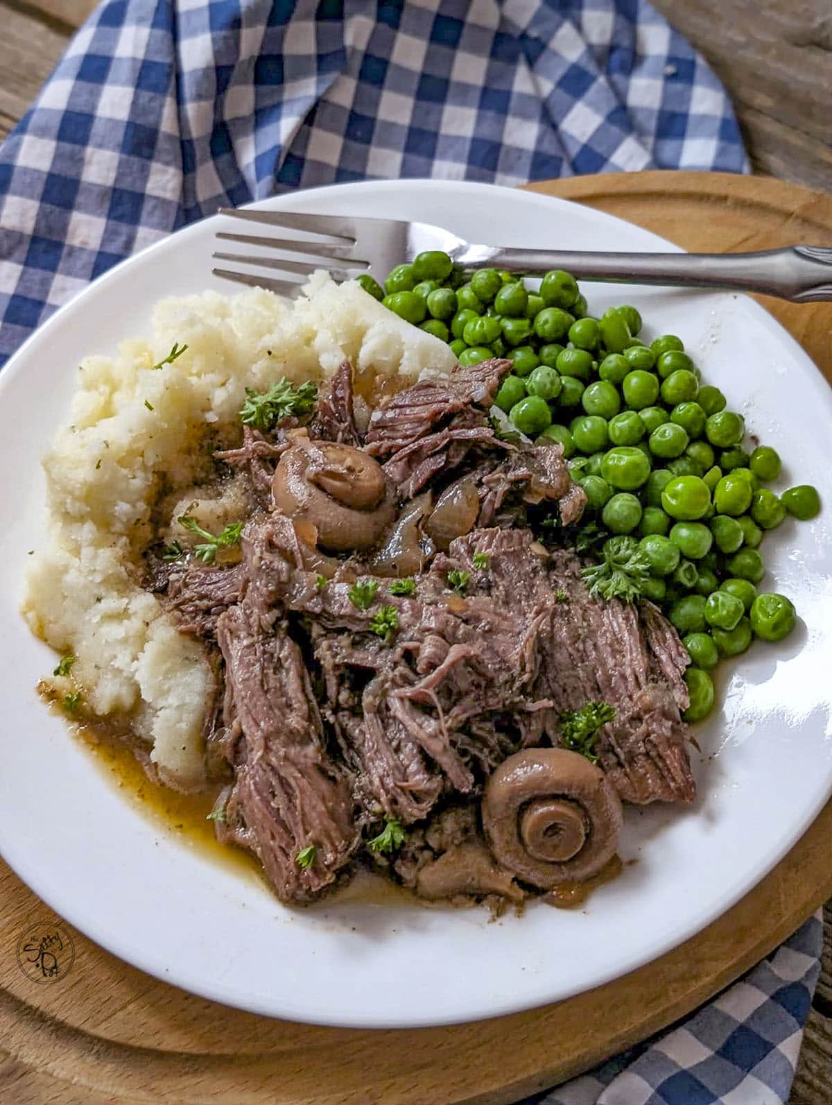 Shredded roast beef served over mashed potatoes and peas