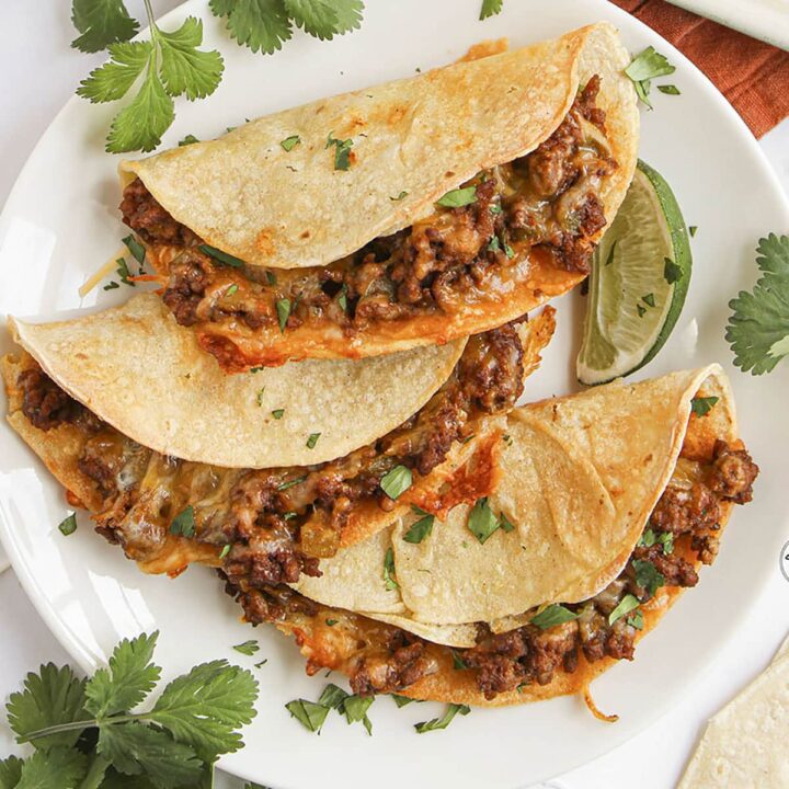 Close-up of cheesy baked beef taco with crispy shell and seasoned ground beef filling