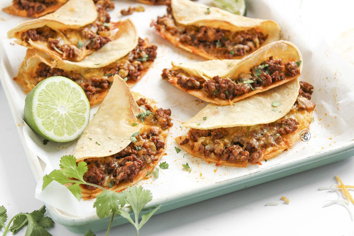 Golden brown baked ground beef tacos with melted cheese and crunchy corn tortillas