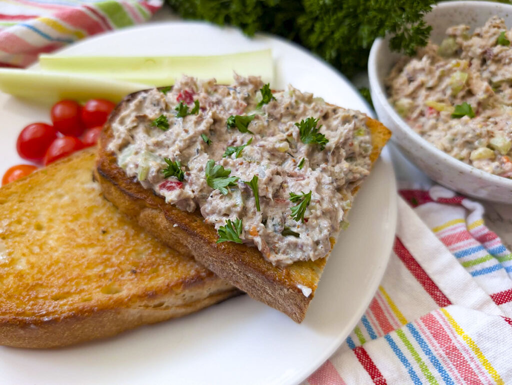 Sardine salad on toast on a white plate.