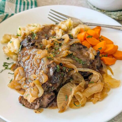 Liver and onions serveed with carrots and mashed potatos