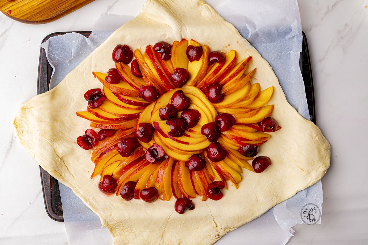Fruit on top of puff pastry, about to folded over to form the galette.