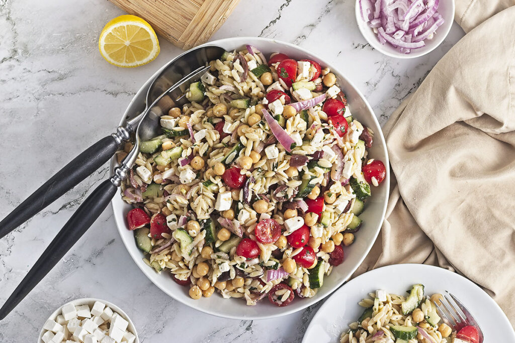 Chickpea orzo salad with feta in a bowl feature image.