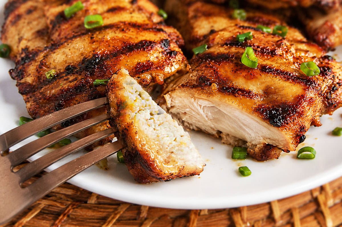A close-up of sliced grilled boneless chicken showing the juicy inside.