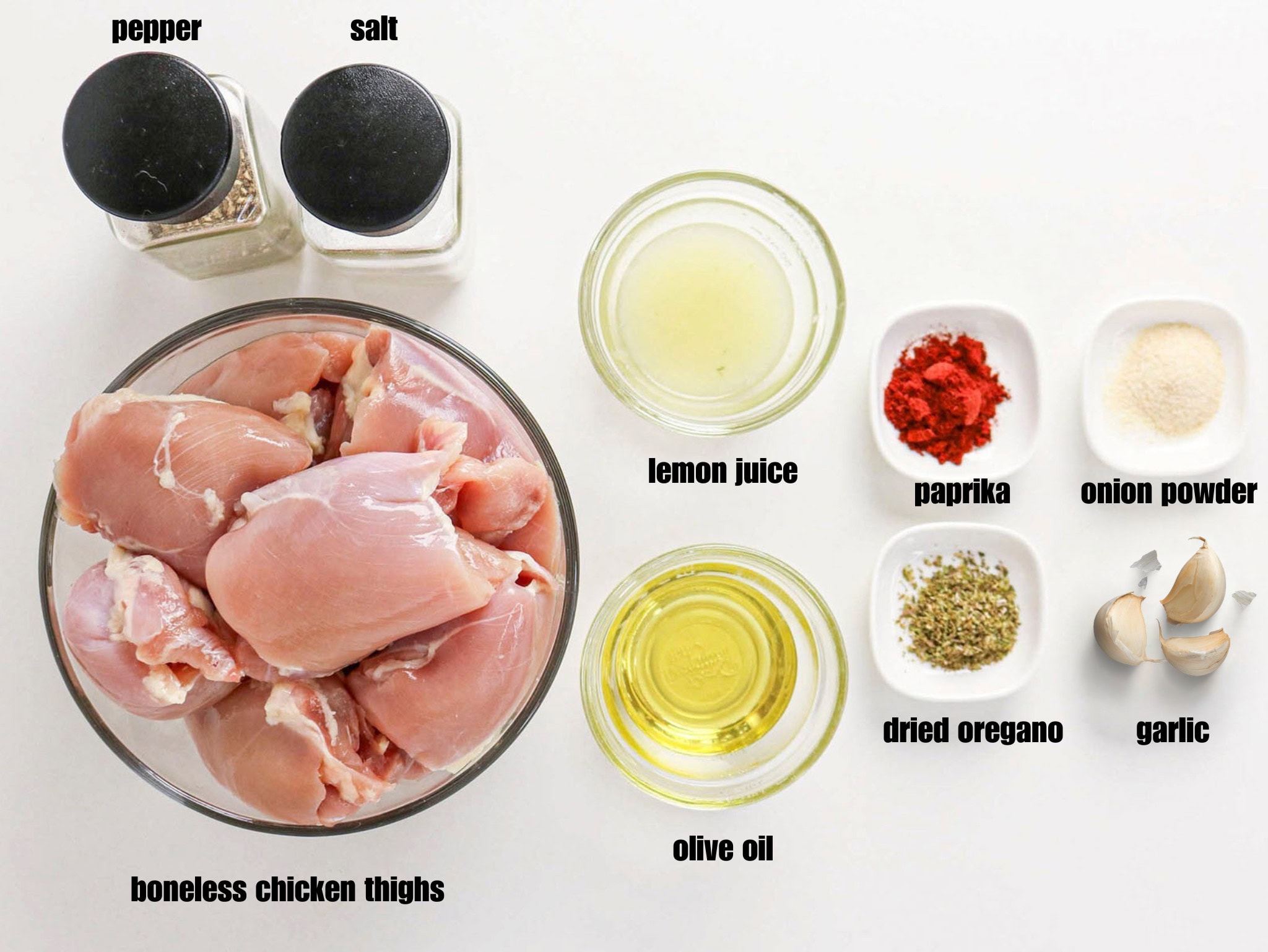 Ingredients for a chicken marinade arranged on a white surface.