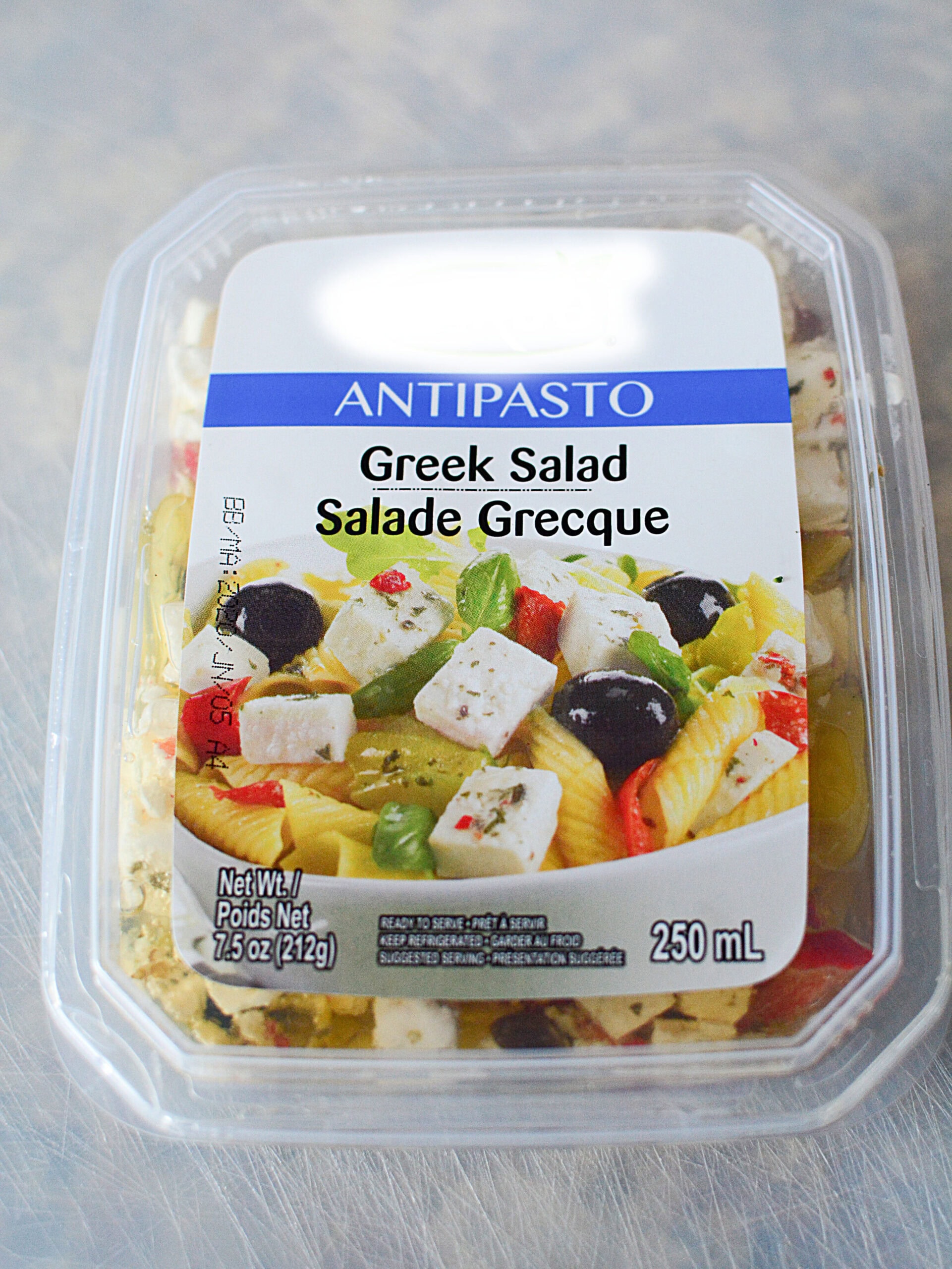 Mediterranean Roasted Vine Tomatoes are a simple and delicious side dish for almost any protein you pair it with! An image of Antipasto Greek Salad in a white plastic container