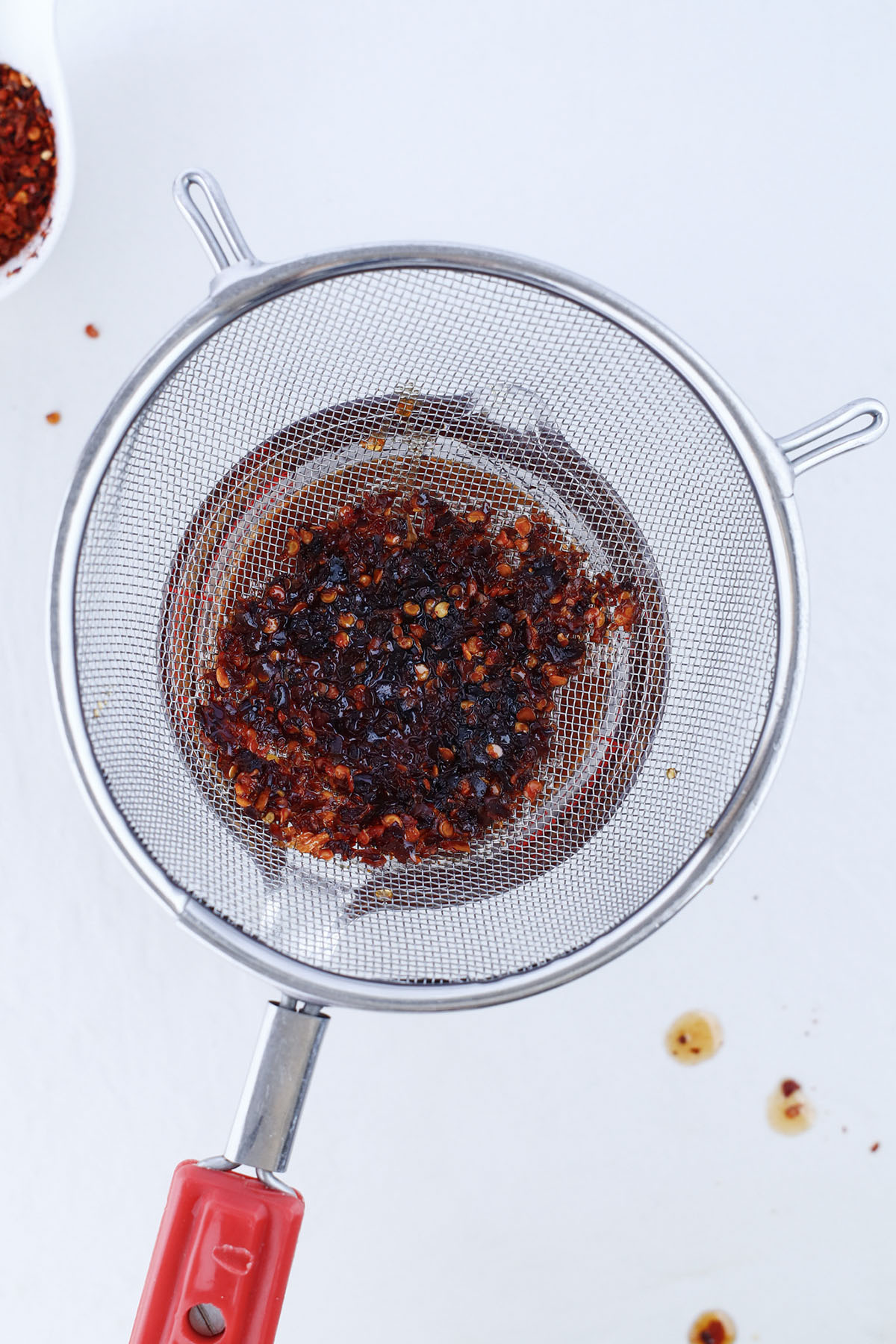 A sieve that is separating the honey from the hot chilis.