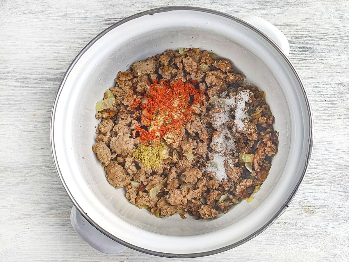 Browned ground meat in a pot seasoned with various ground spices
